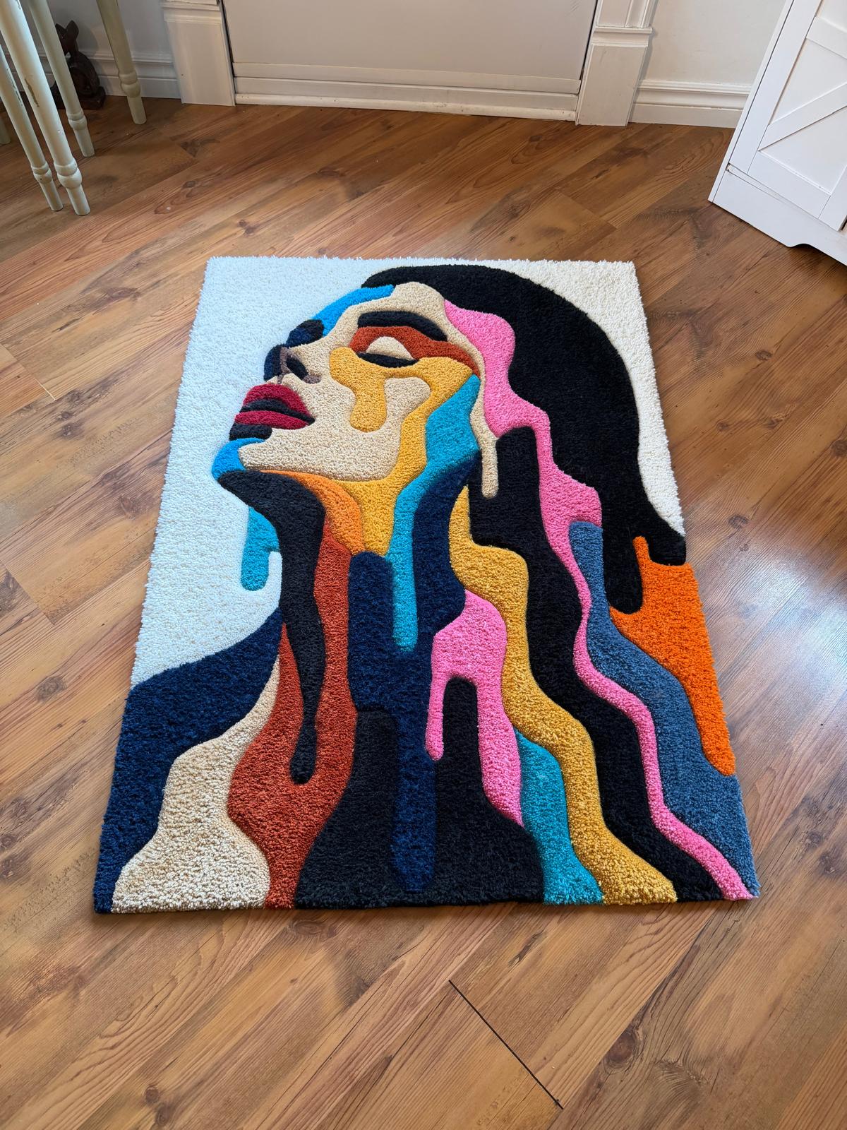 Angled view of colourful melting portrait rug showing sculpted texture
