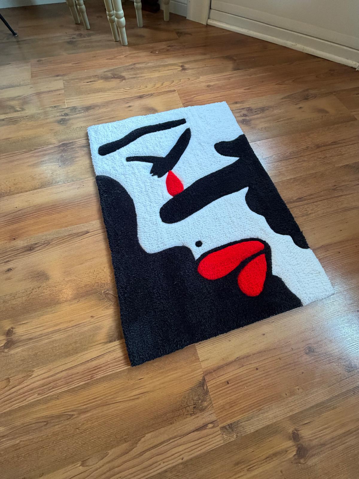 Abstract face rug in black, white and red on a wood floor